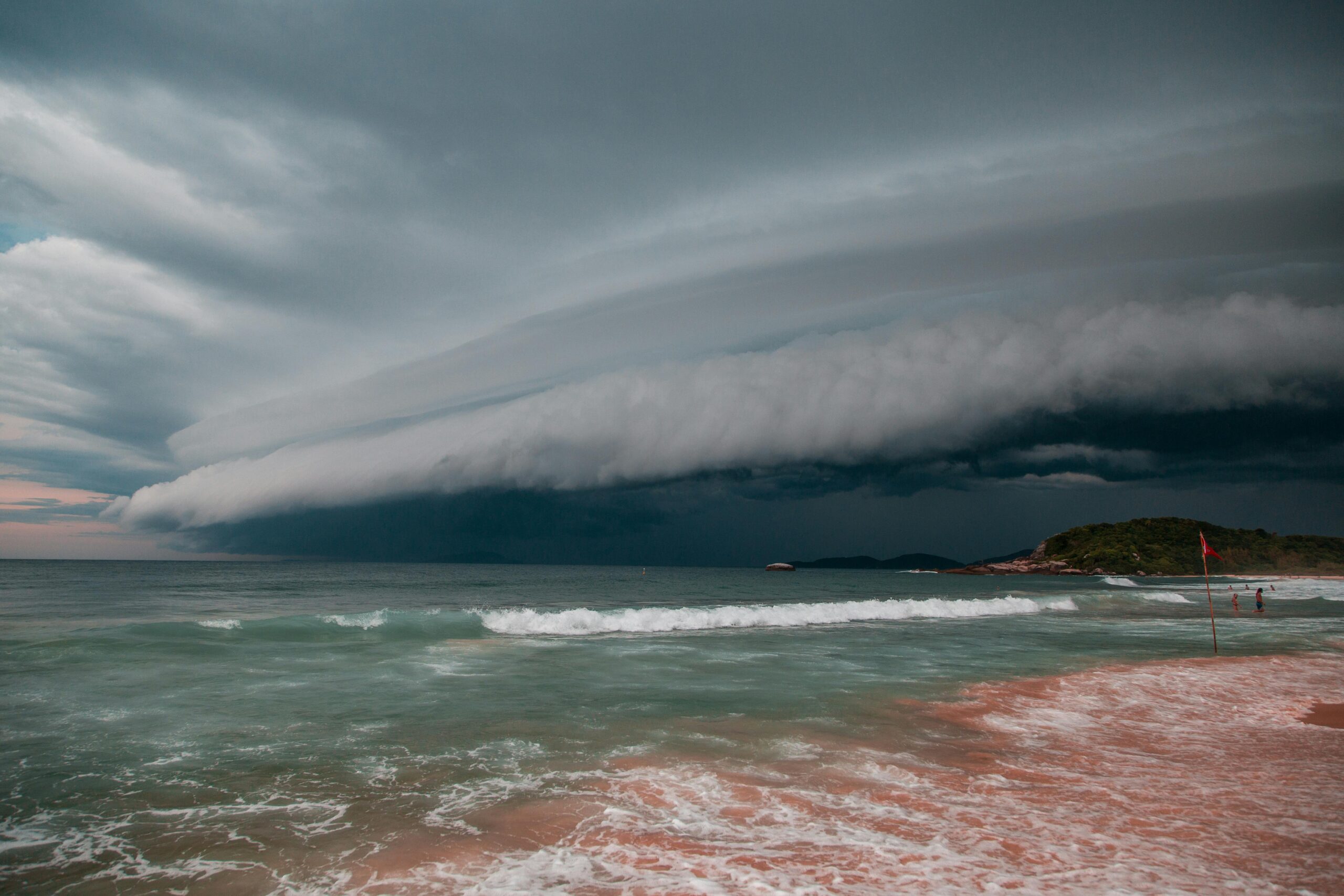 Supporting Yourself in the Storms A dramatic thunderstorm approaches the beach, creating a striking cloudscape over the ocean waves.